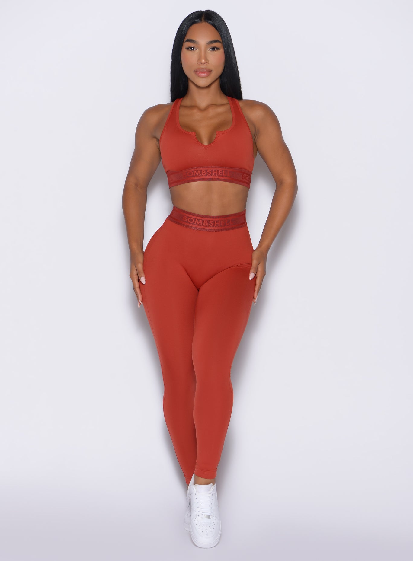 front profile view of our model wearing the Bombshell Active Leggings in red ochre color paired with the matching bra