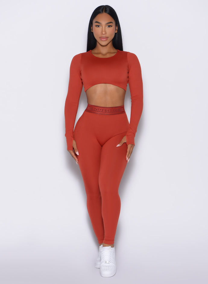 front profile view of our model wearing the  Bombshell Active Leggings in red ochre color