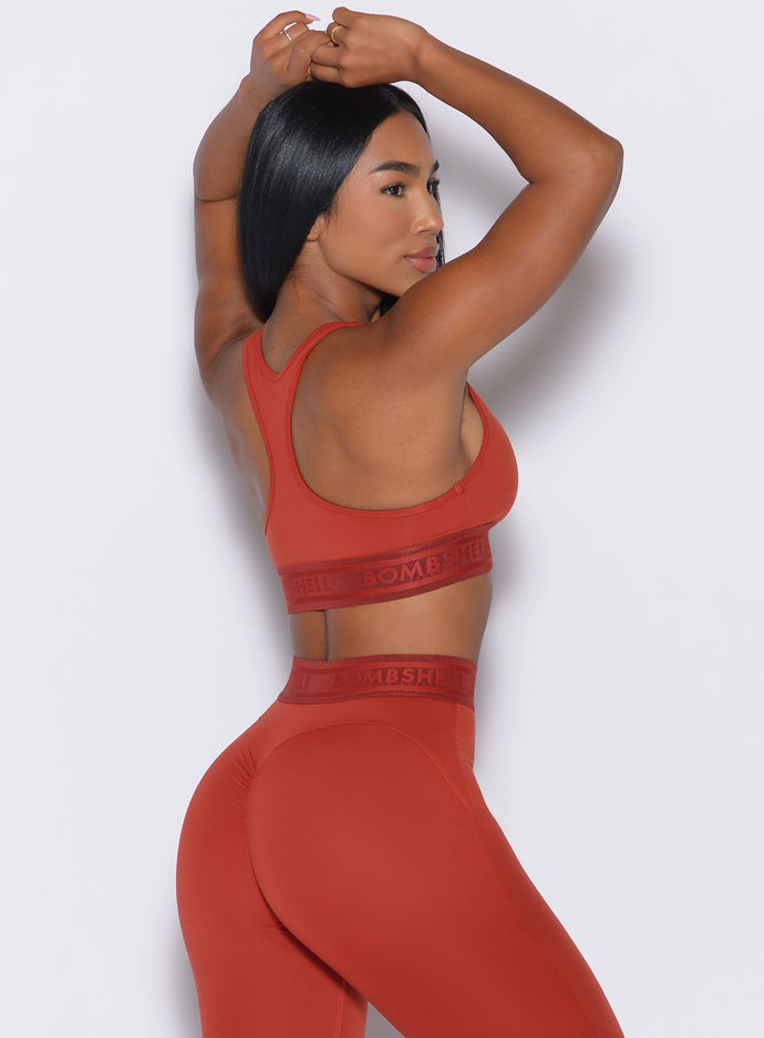 right side profile view of our model wearing the Bombshell Active Bra in Red Ochre color