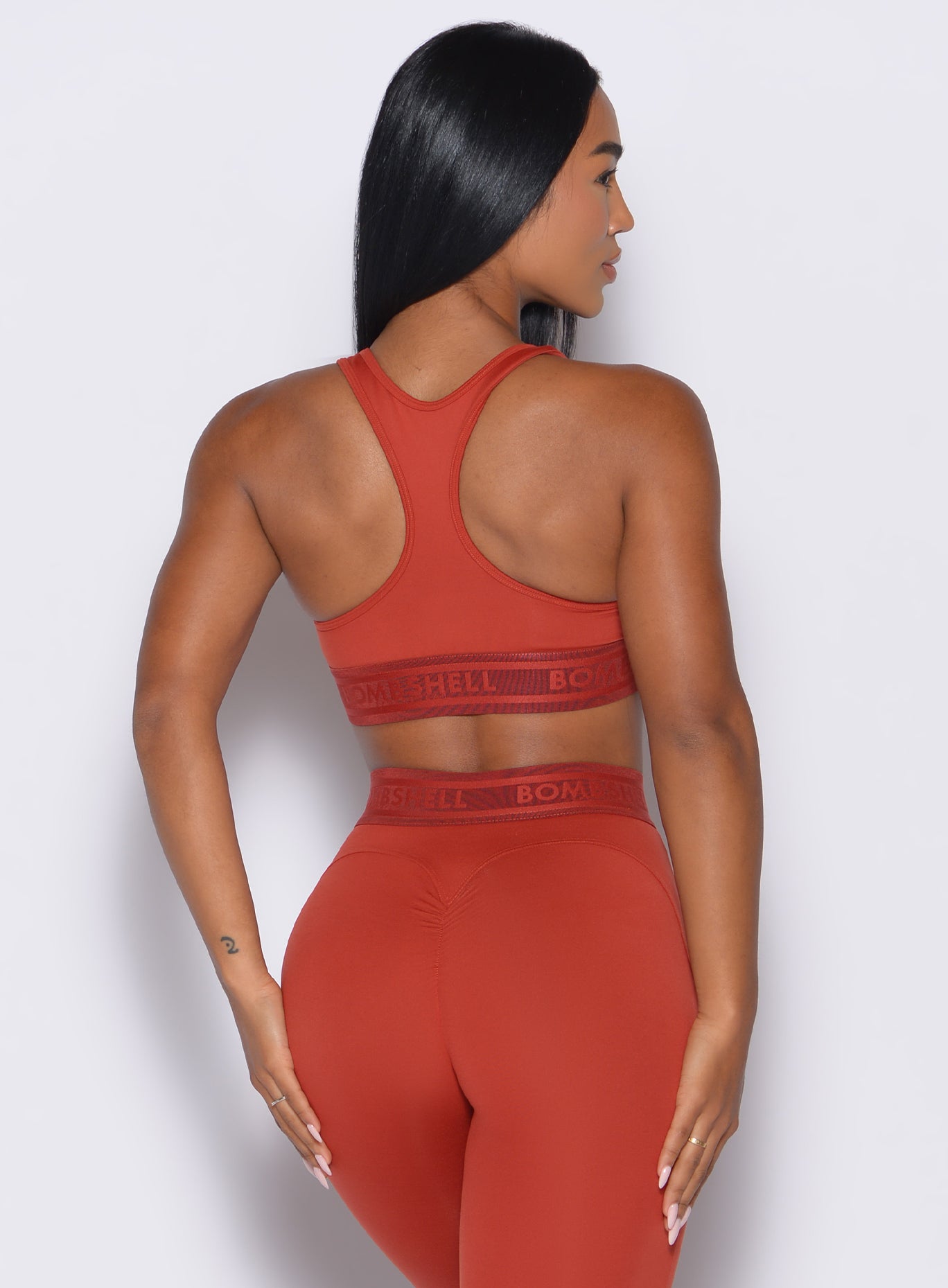 back profile view of our model wearing the Bombshell Active Bra in Red Ochre color