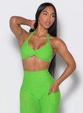 front profile view of a model wearing our butterfly sports bra in neon lime green color along with the matching leggings 