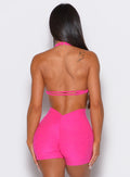 back profile picture of a model wearing our butterfly sports bra in Neon Pink Berry color along with a matching shorts