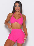 front profile view of a model wearing our butterfly sports bra in Neon Pink Berry color along with a matching shorts 