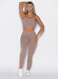 front profile view of a model wearing our cheeky seamless leggings in Soft Mocha color along with the matching bandeau