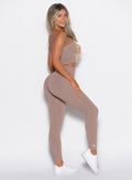 right side profile view of a model facing to her right wearing our cheeky seamless leggings in Soft Mocha color along with the matching bandeau