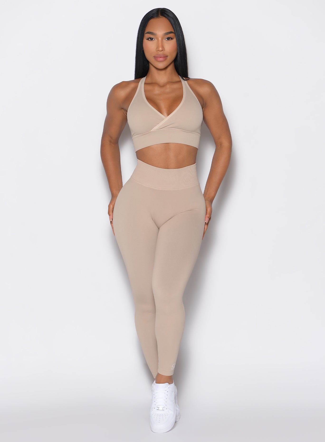 front profile view of a model wearing our cheeky seamless leggings in Timeless Taupe color along with the matching sports bra 