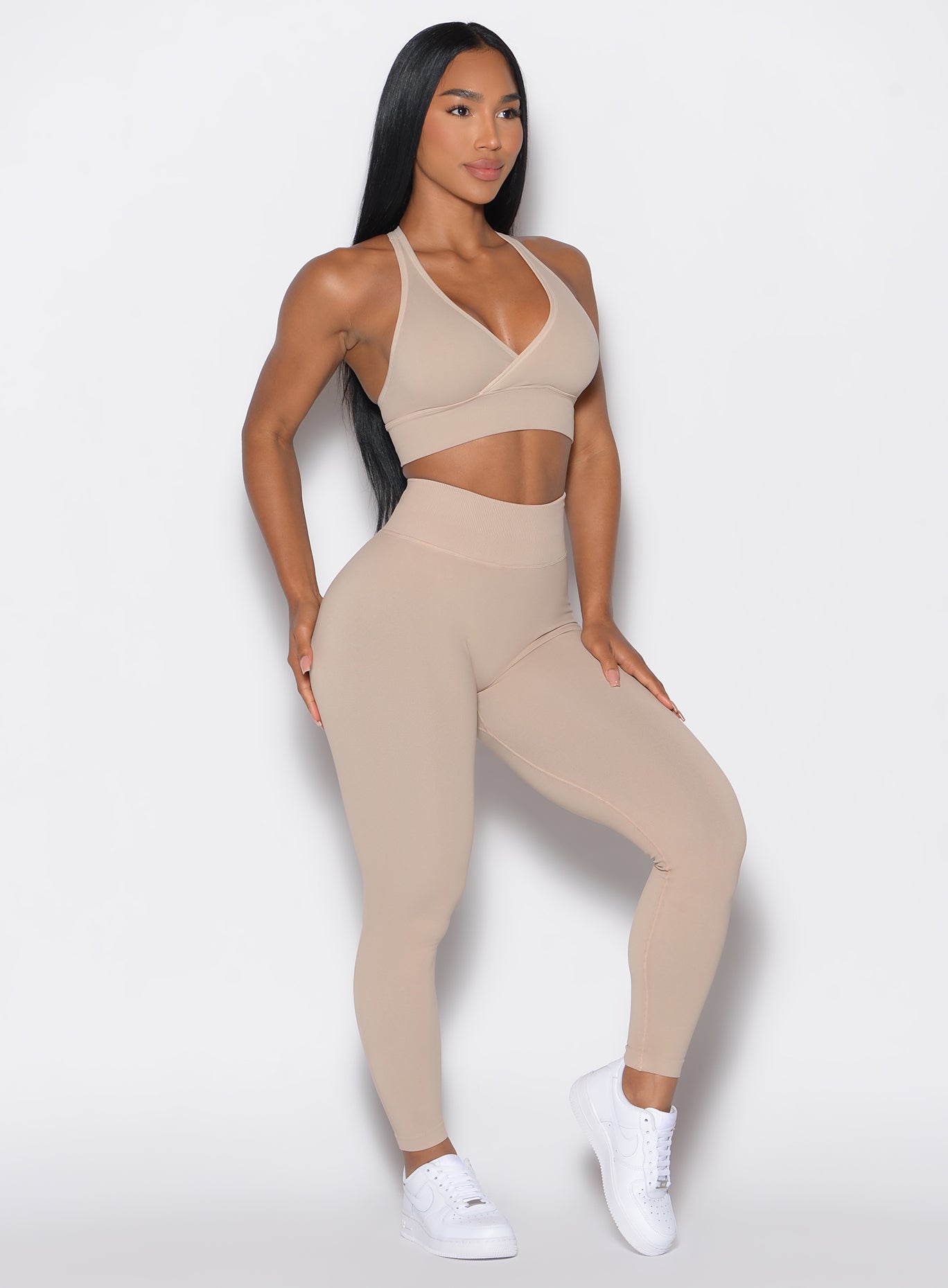 front profile view of a model wearing our cheeky seamless leggings in Timeless Taupe color along with the matching bra