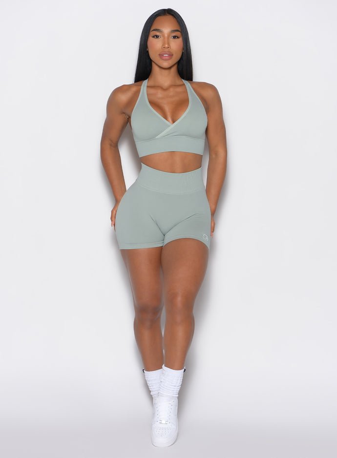 front profile view of a model facing forward  wearing our cheeky seamless shorts in soft mocha color along with a matching sports bra