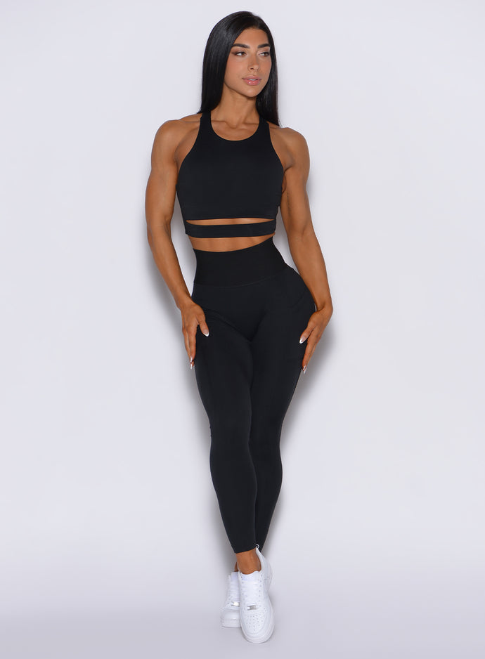 Front profile view of a model in our black cincher leggings and a matching top 