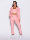 front profile view of a model wearing the Cloud Comfort Joggers in Peachy pink color with one hand inside the pocket of the joggers