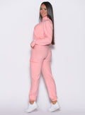 left side profile view of a model wearing the Cloud Comfort Joggers in Peachy pink color paired with the matching jacket