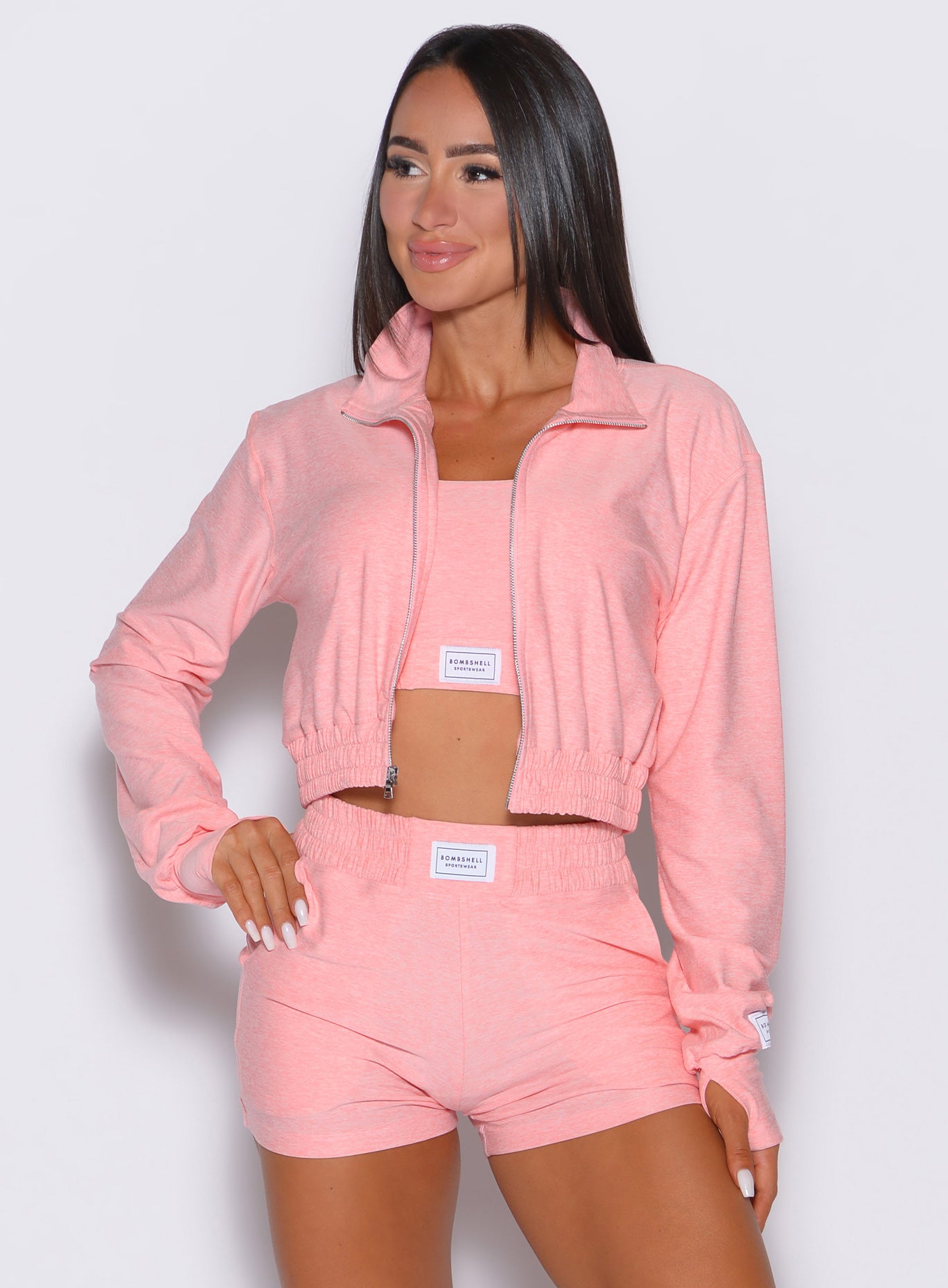 front profile view of a model looking to the right side wearing the Cloud Crop Jacket in Peachy pink color