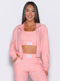 front profile view of a model with the front zipper opened on the Cloud Full Length Jacket in Peachy pink color