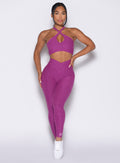 Model facing forward wearing our Contour Leggings and the matching Cross Over Halter Bra in Bright Plum color