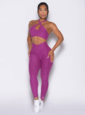 front profile view of a model wearing our Contour Leggings and the matching Cross Over Halter Bra in Bright Plum color