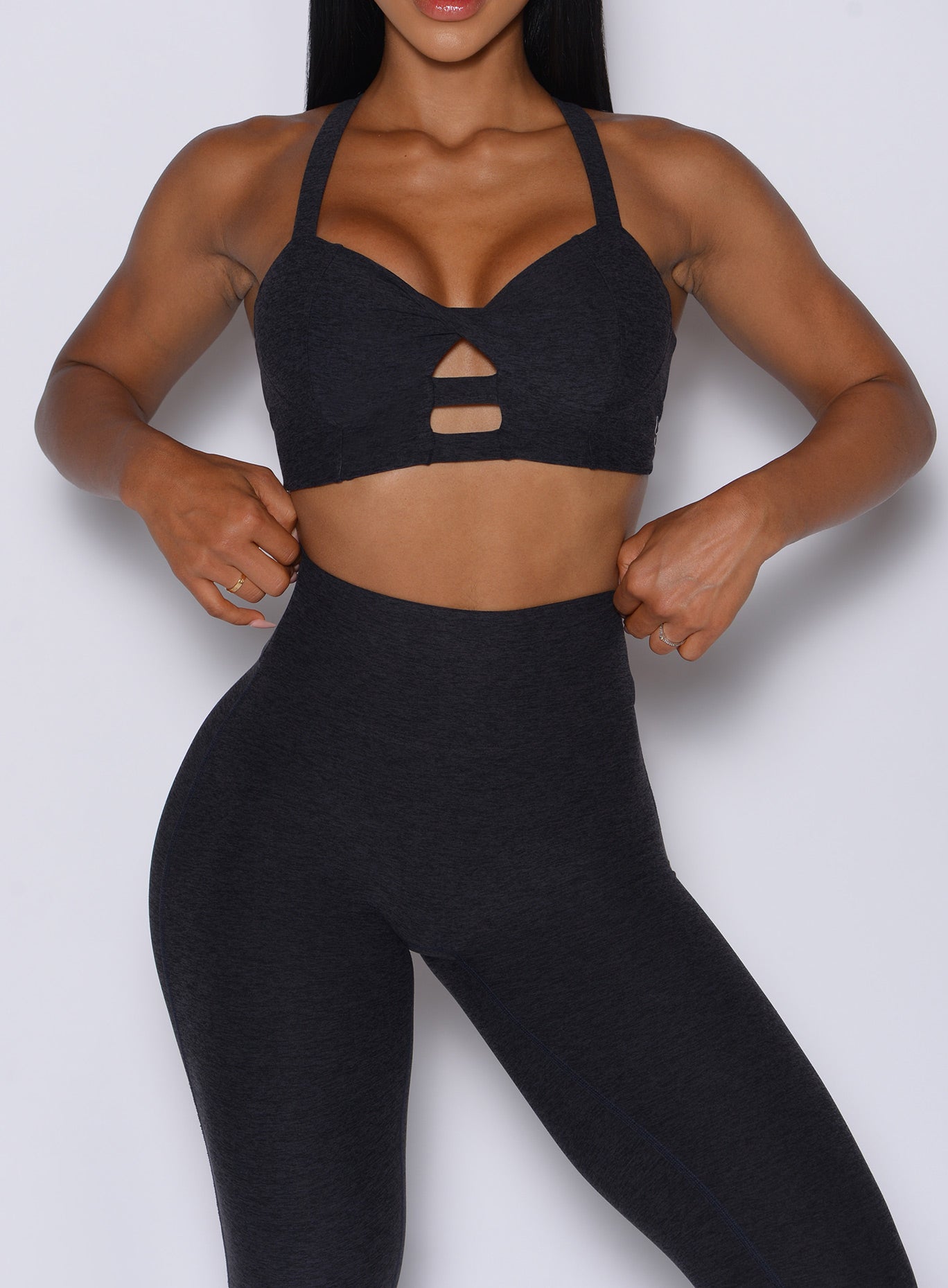 front profile view of a model wearing our black core set bra along with the matching leggings