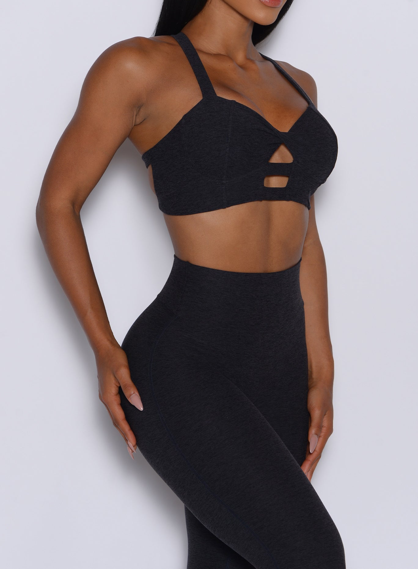 right side profile view of a model wearing our black core set bra along with the matching leggings