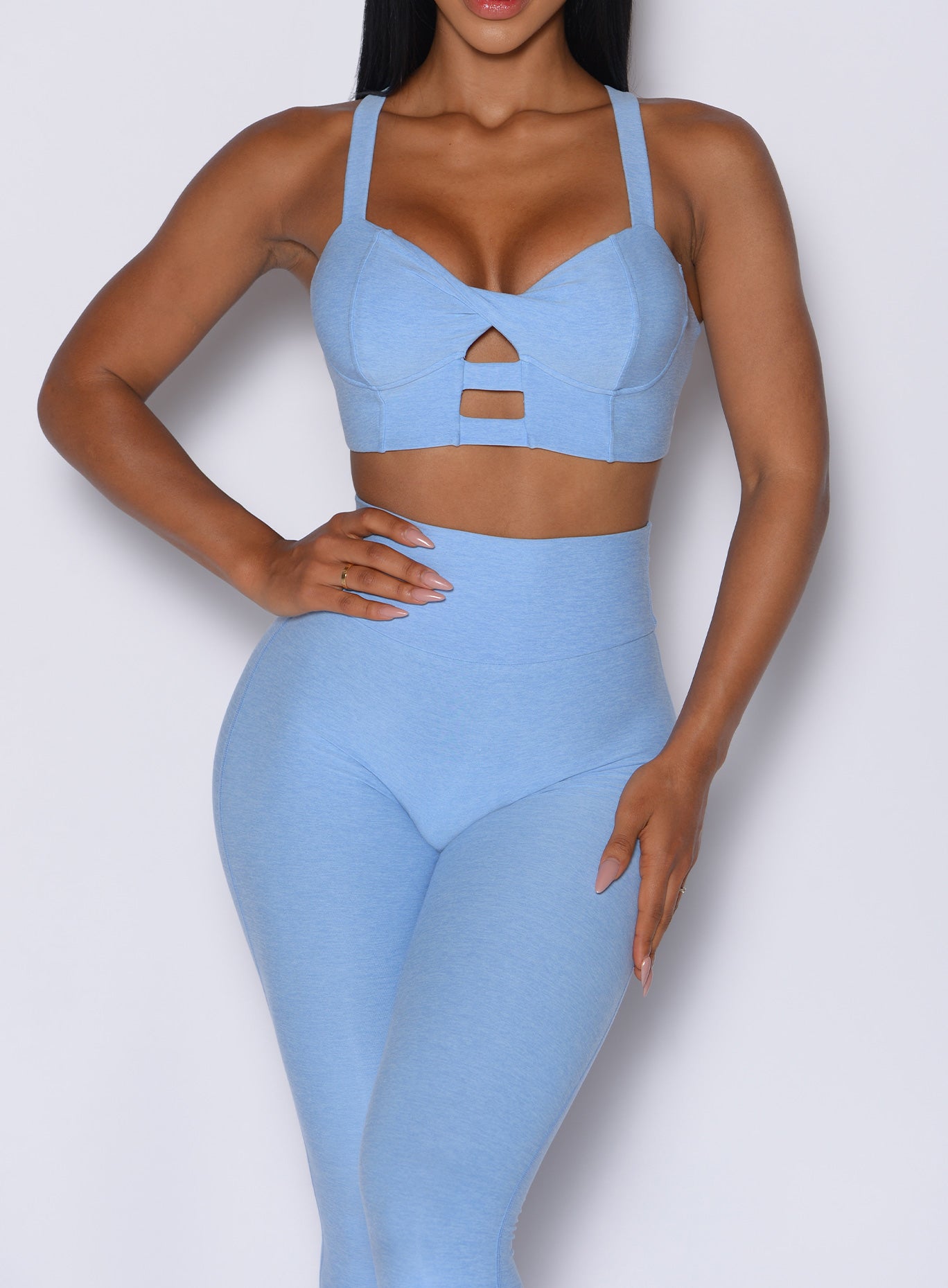 front profile view of a model wearing our core set bra in bright hydrangea color along with the matching leggings