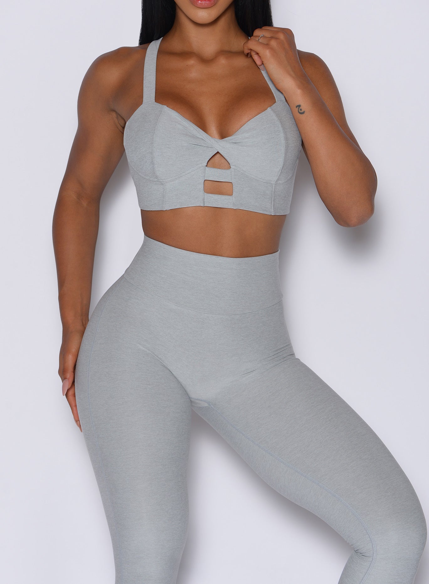 front profile view of a model wearing our core set bra in light cloud color along with the matching leggings