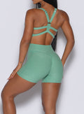 Zoomed in back side view of our Tiny Waist Shorts in Sage color and a matching sports bra