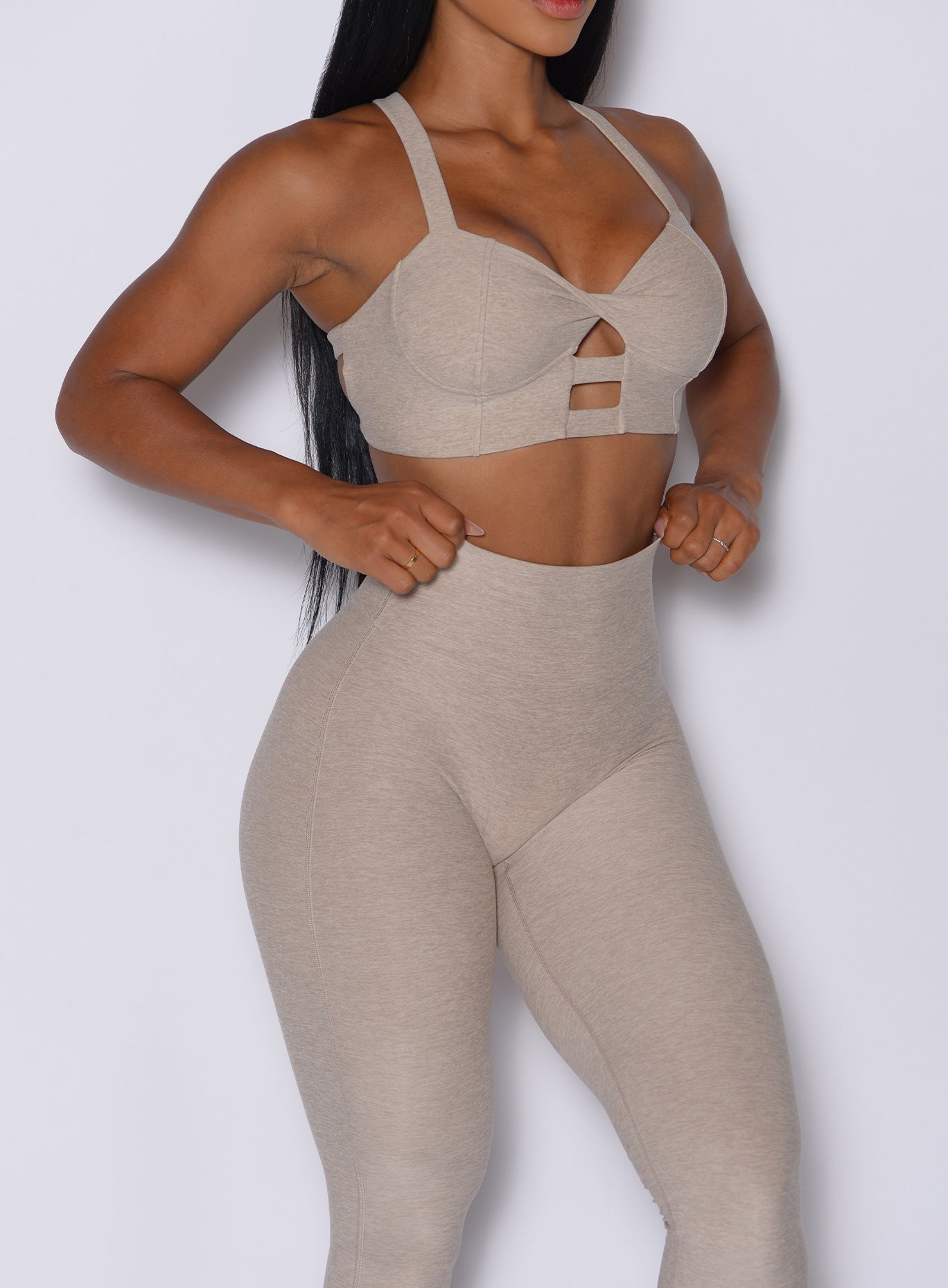 front profile picture of a model wearing our core set bra in taupe color along with the matching leggings