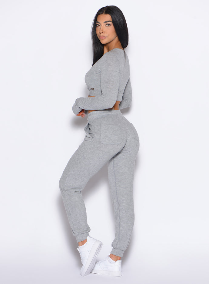 left side profile view of a model looking over her shoulder wearing the Cuddle Up Joggers in Cozy Silver color