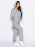 front right side profile view of a model wearing the Flirty Jumpsuit in Cozy silver color