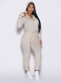 front profile view of model wearing the Flirty Jumpsuit zipped with hoodie on in Cozy Oat color 