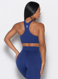 back profile of model wearing the Cross Over Halter Bra and the matching leggings in Royal Indigo color