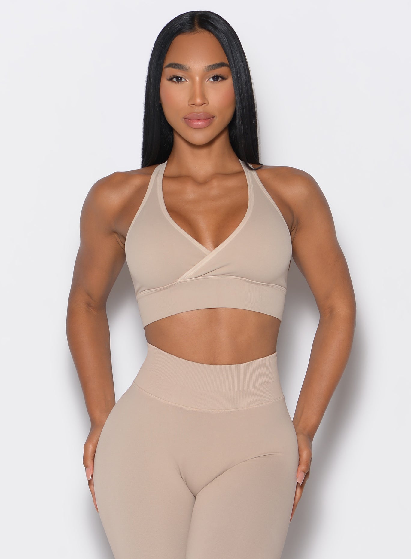 model facing forward wearing our cross over bra in timeless taupe color along with the matching leggings