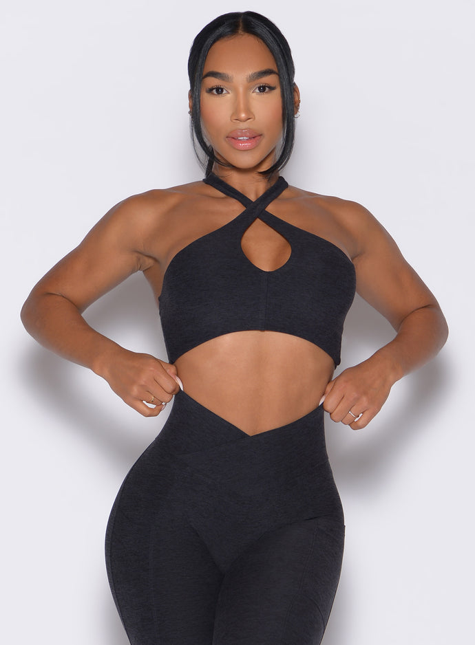 Model facing forward wearing our Cross Over Halter Bra and the matching leggings in Heathered Black color