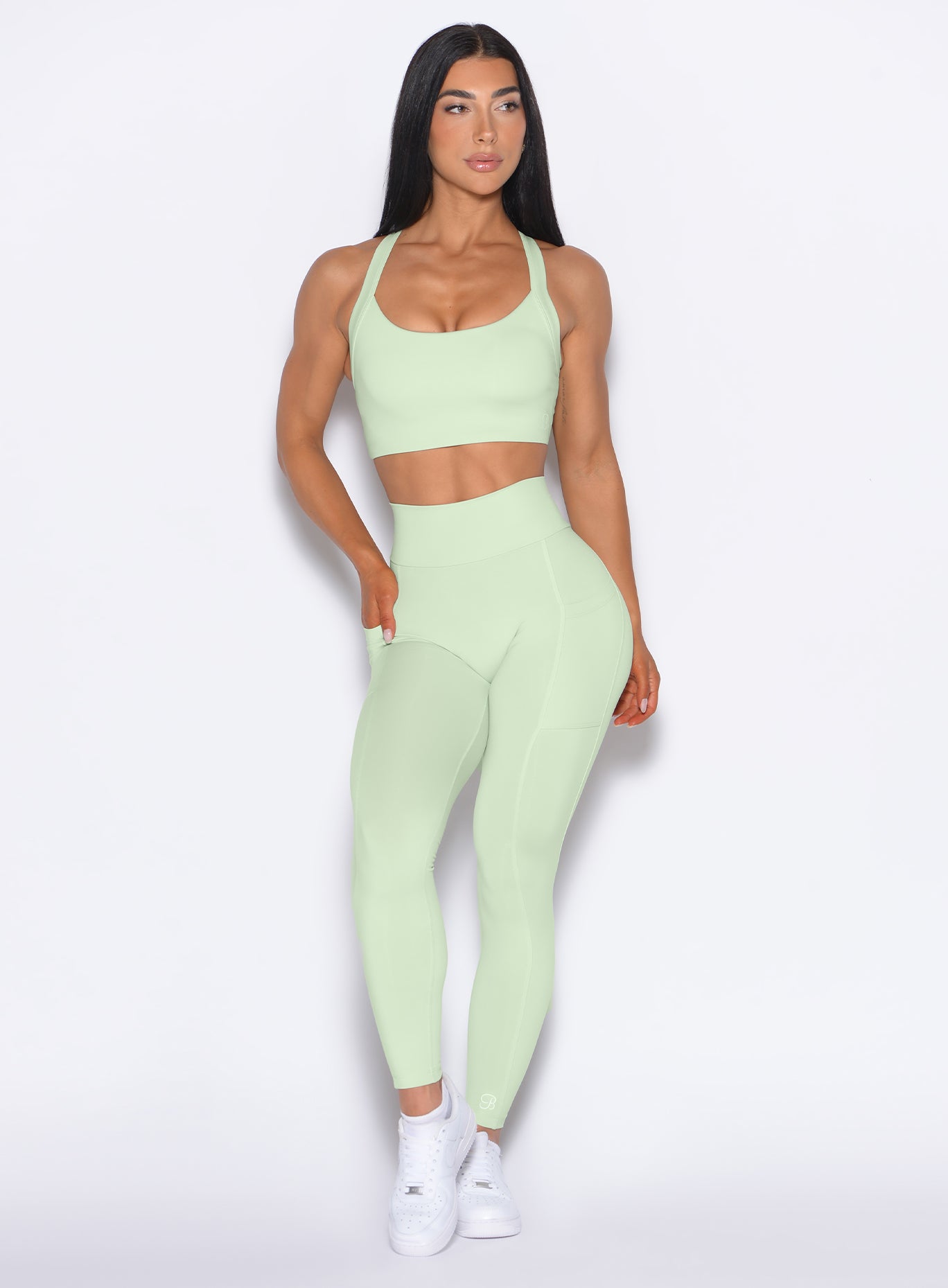 front profile view of our model looking to the left wearing the Curves 2.0 Leggings in Cool Matcha color