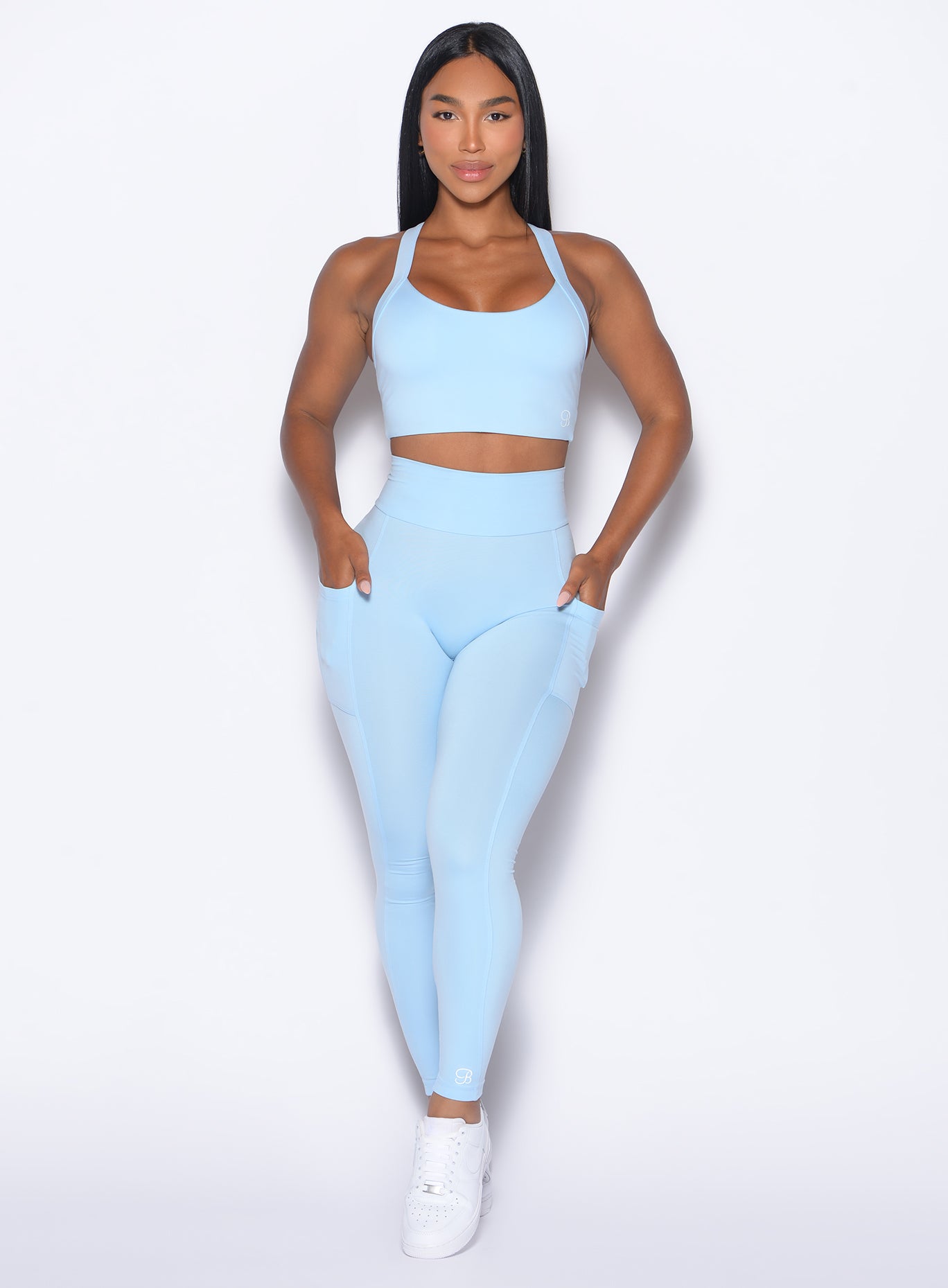 front profile view of our model with both hands in the pockets of the leggings wearing the Curves 2.0 Leggings in Glacial Blue color