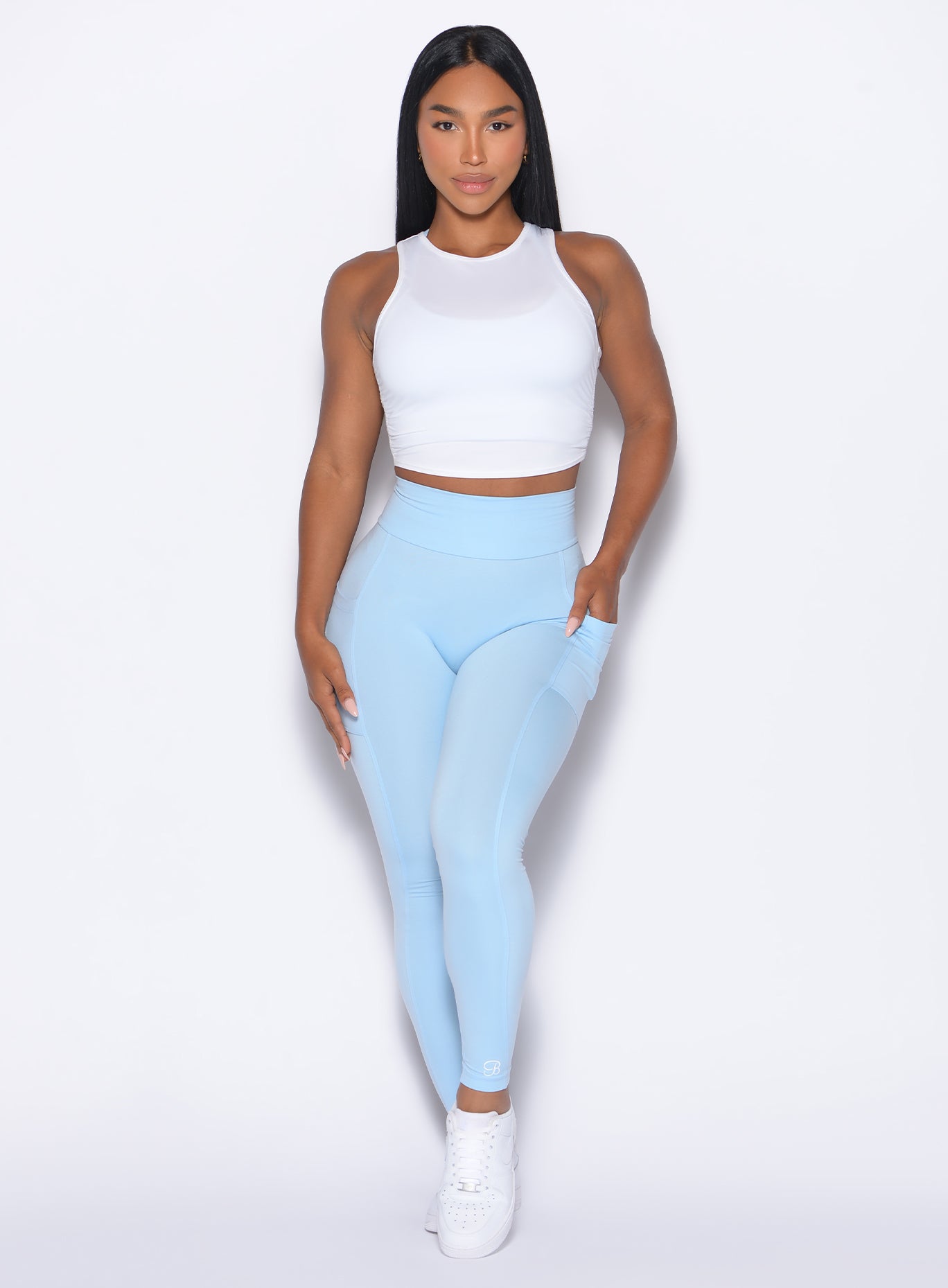 front profile view of our model wearing the Curves 2.0 Leggings in Glacial Blue color paired with the  Muscle Scrunch tank in white color