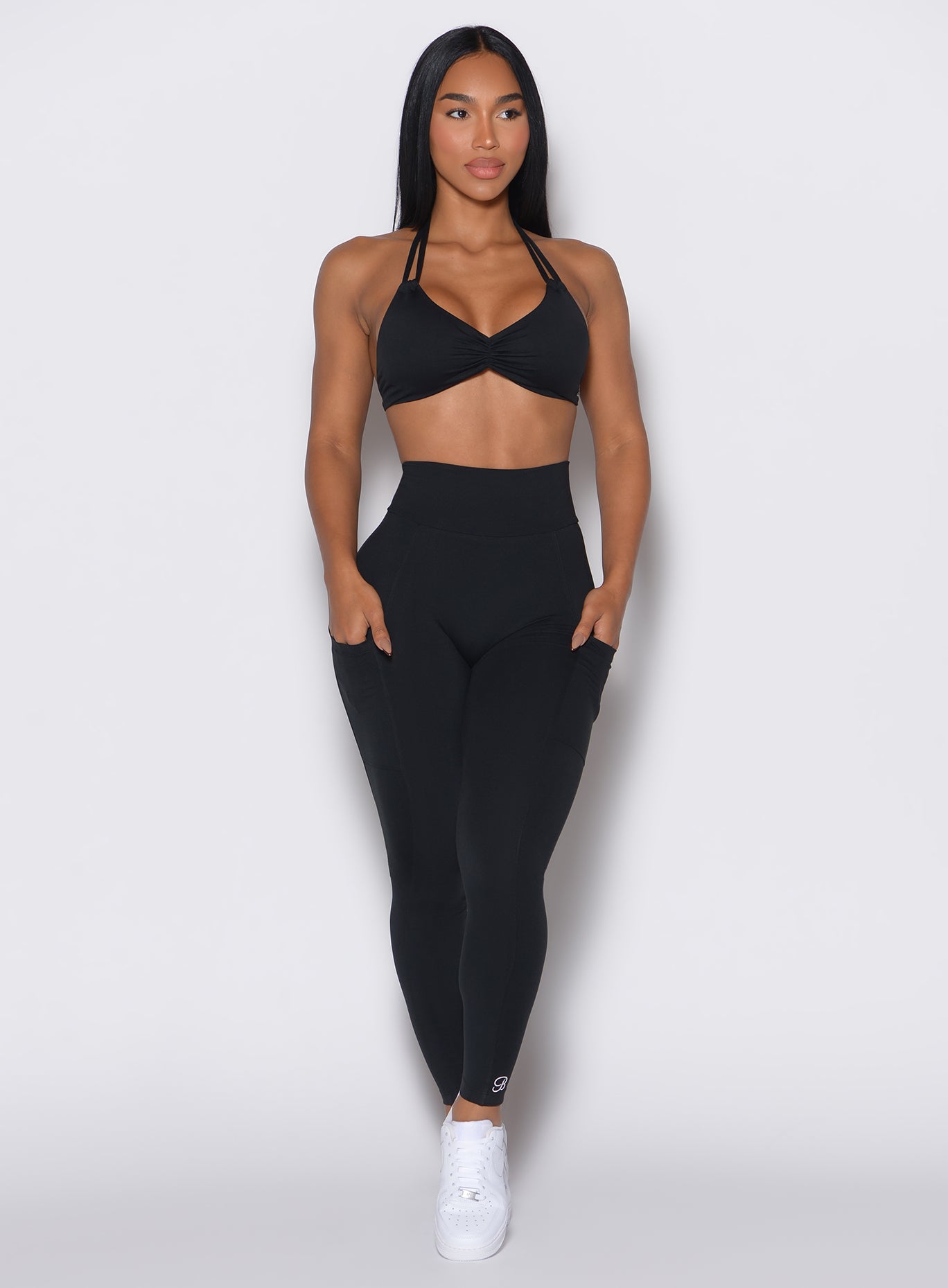 front profile view of a model wearing our black curves leggings along with a matching sports bra 
