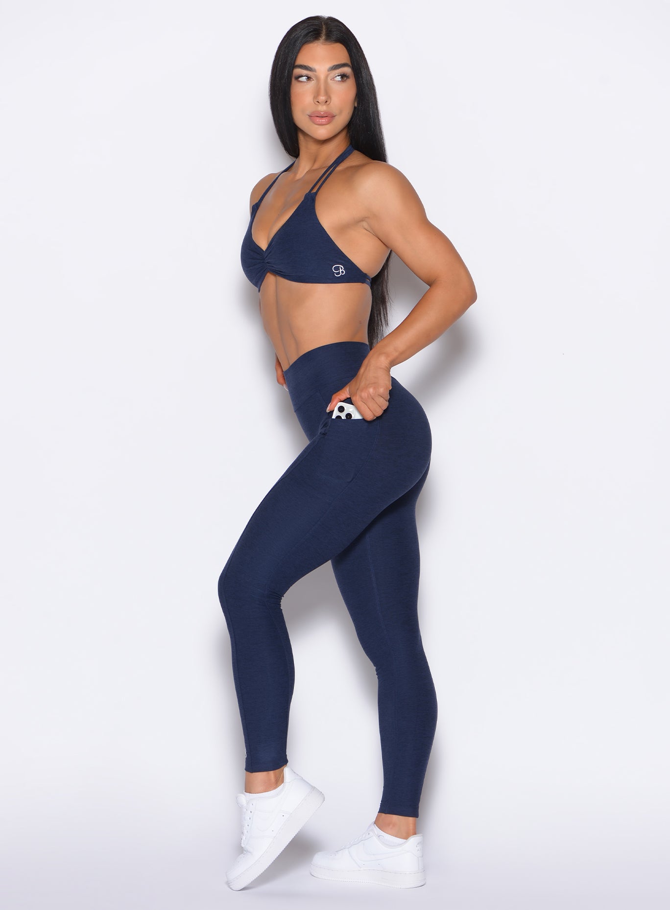 left side profile view of our model looking over her shoulder wearing the Curves 2.0 Leggings in Cosmic Blue color