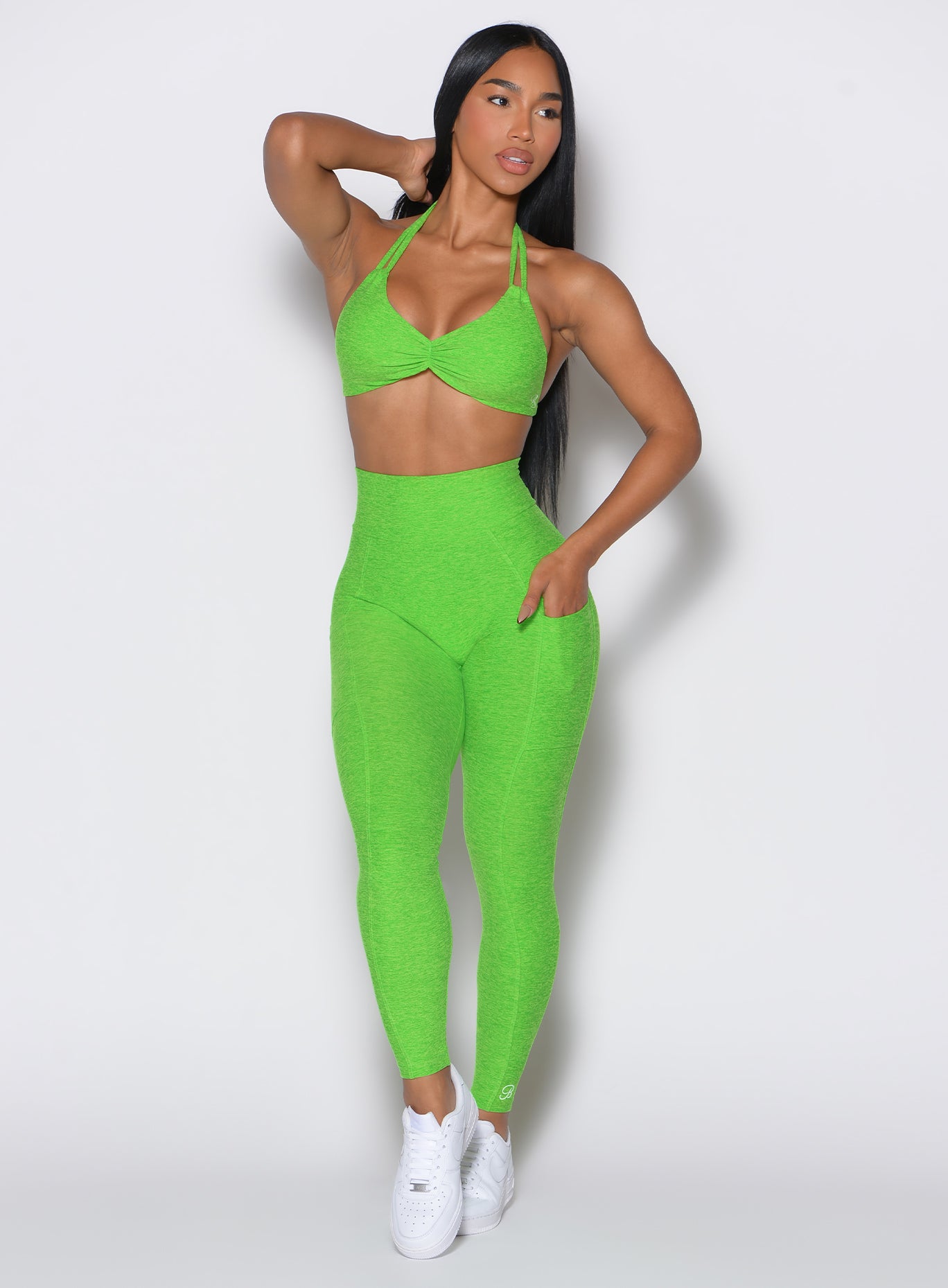 front profile view of a model wearing our curves leggings in Neon Lime Green color along with the matching sports bra 