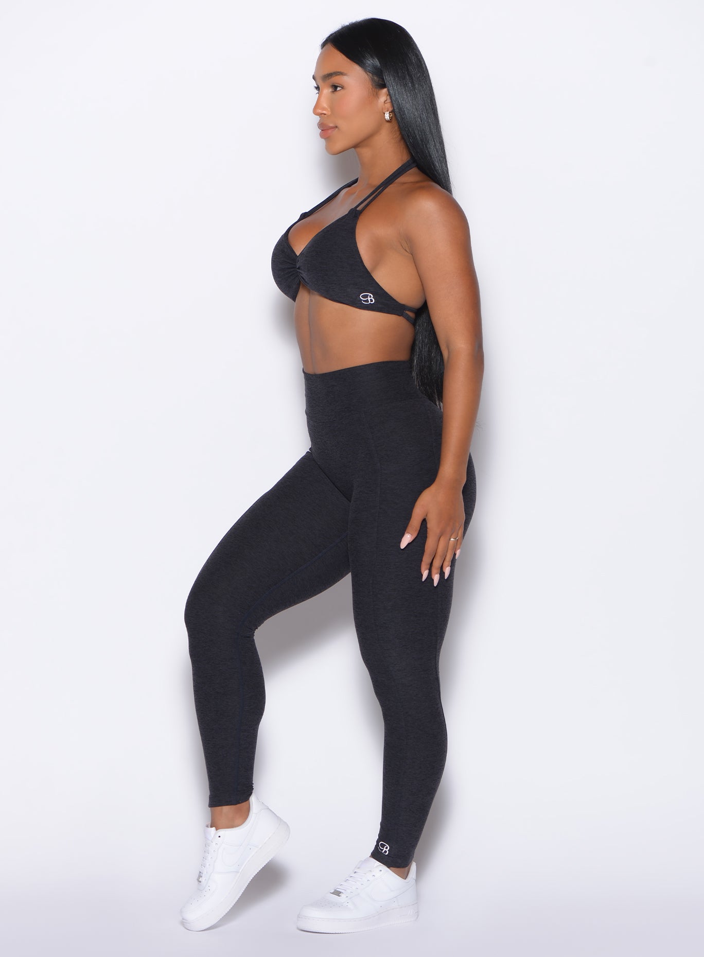 left side profile view of our model facing forward wearing the Curves 2.0 Leggings in Onyx color