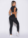 back right side profile view of a model wearing the Define Leggings in Black color paired with the matching top