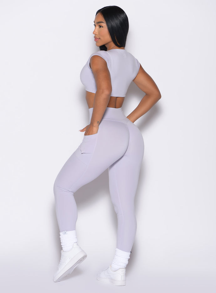 back left side profile view of a model wearing the Define Leggings in Galactic Lilac color paired with the matching top