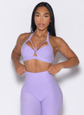 front profile view of a model adjusting the waistband of the leggings wearing the Iron Edge Bra in Sugared Lilac color