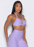 front right side profile view of a model wearing the Iron Edge Bra in Sugared Lilac color paired with the matching leggings