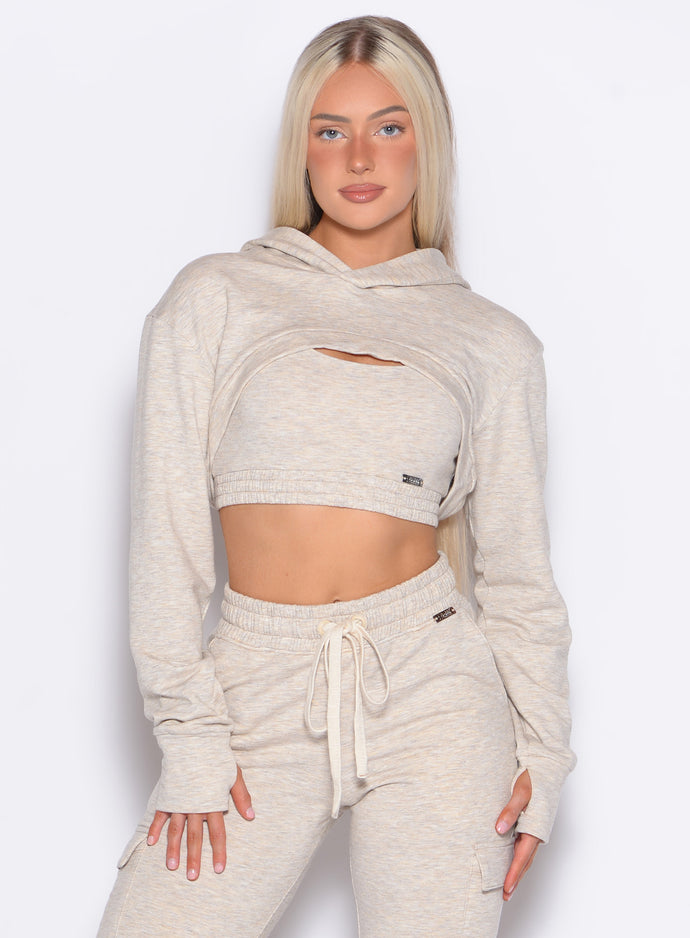 front profile view of a model posing in our Sweat Bolero Hoodie and the matching Joggers in Heathered Oatmeal color