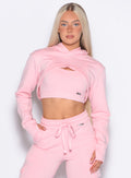 front profile view of a model posing in our Sweat Bolero Hoodie and the matching Joggers in Tickled Pink color
