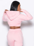 Back side close up view of model wearing the Sweat Bolero Hoodie and the matching Joggers in Tickled Pink color