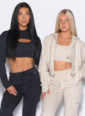 Two models standing side by side, model on the left wearing our Sweat Bolero Hoodie and the matching Joggers in Vintage Black color and the other wearing the Sweat Hoodie and the matching Joggers in Heathered Oatmeal color