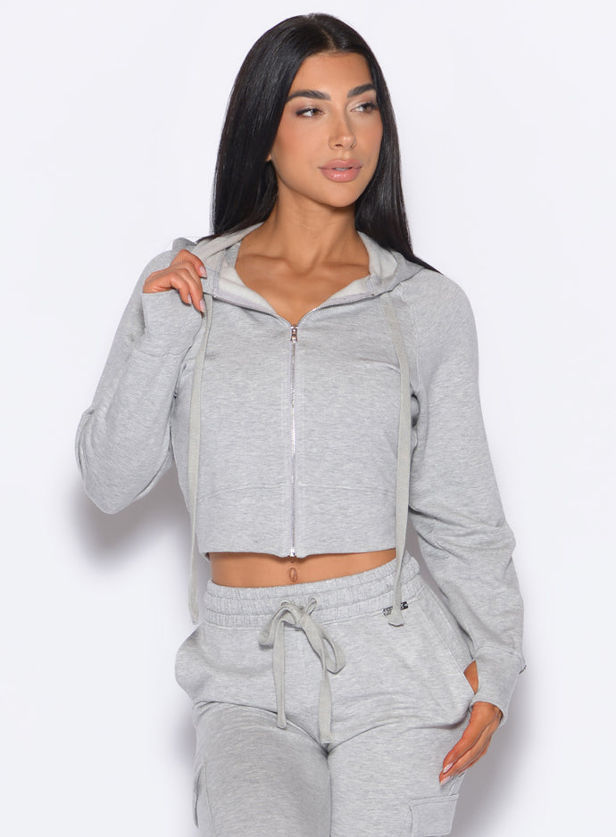 front profile view of our model with the hoodie zipper closed wearing the Sweat Hoodie in Light heather grey color