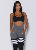 Front profile view of a model in our black glow sports bra and a matching thigh high leggings 