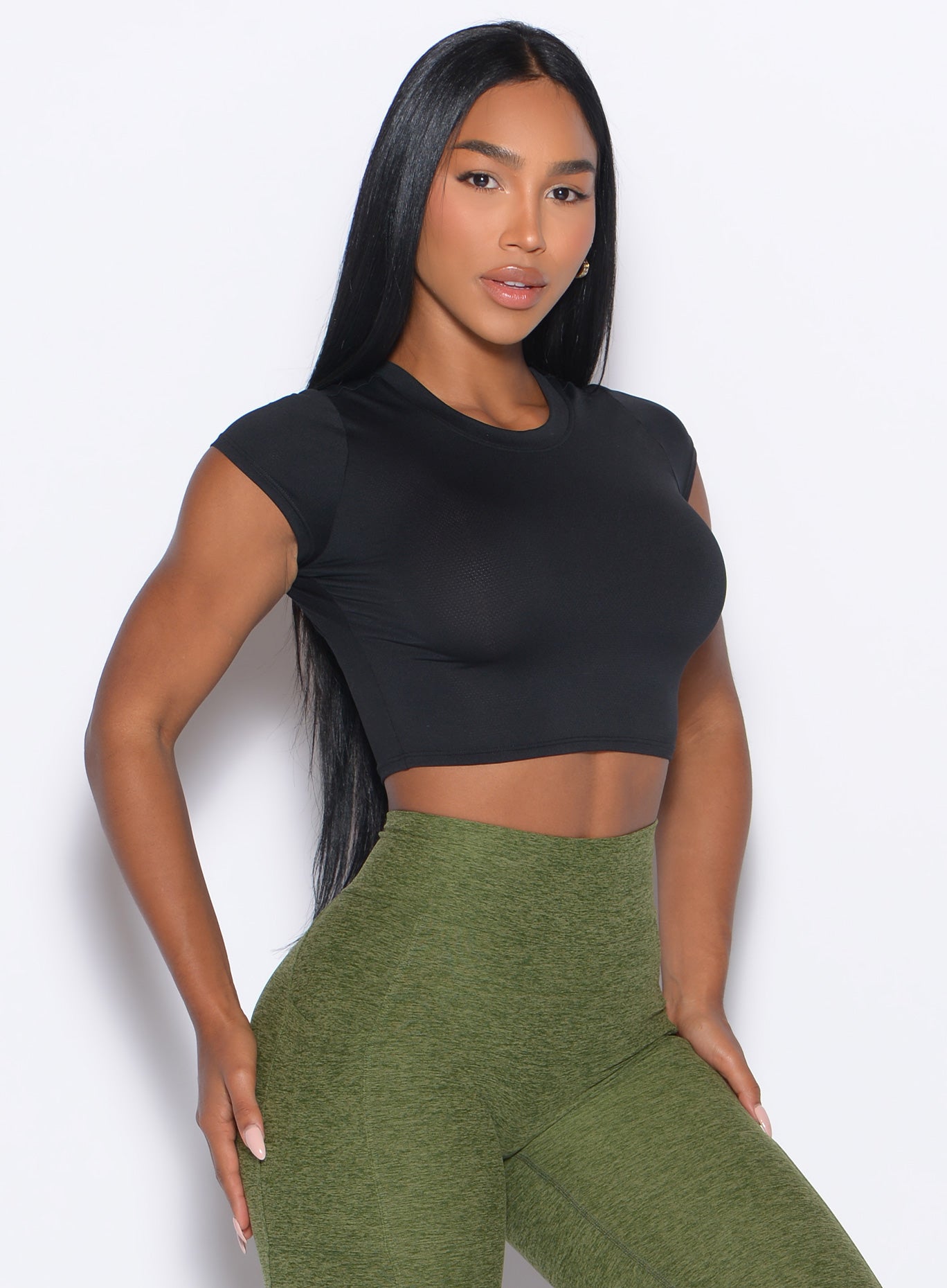 front profile picture of a model in our Flex Crop Tee in Black color and the Curves 2.0 Leggings in Juniper color
