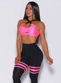 Front profile view of a model in our glow sports bra in neon pink and a matching leggings 